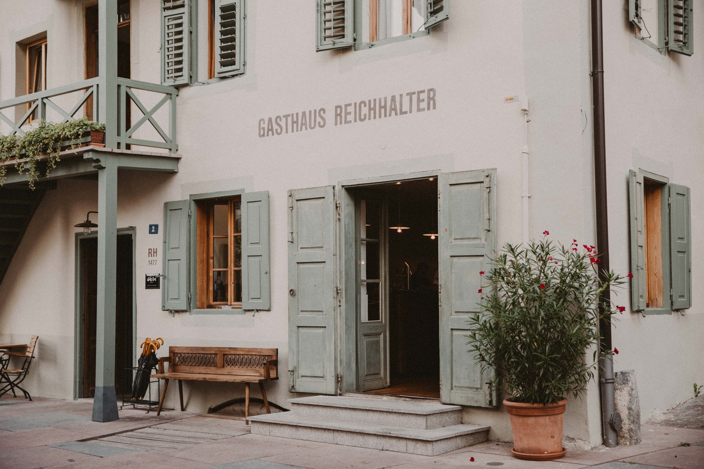 1477 Reichhalter — Eingang mit grünen Fensterläden und Schriftzug Gasthaus Reichhalter