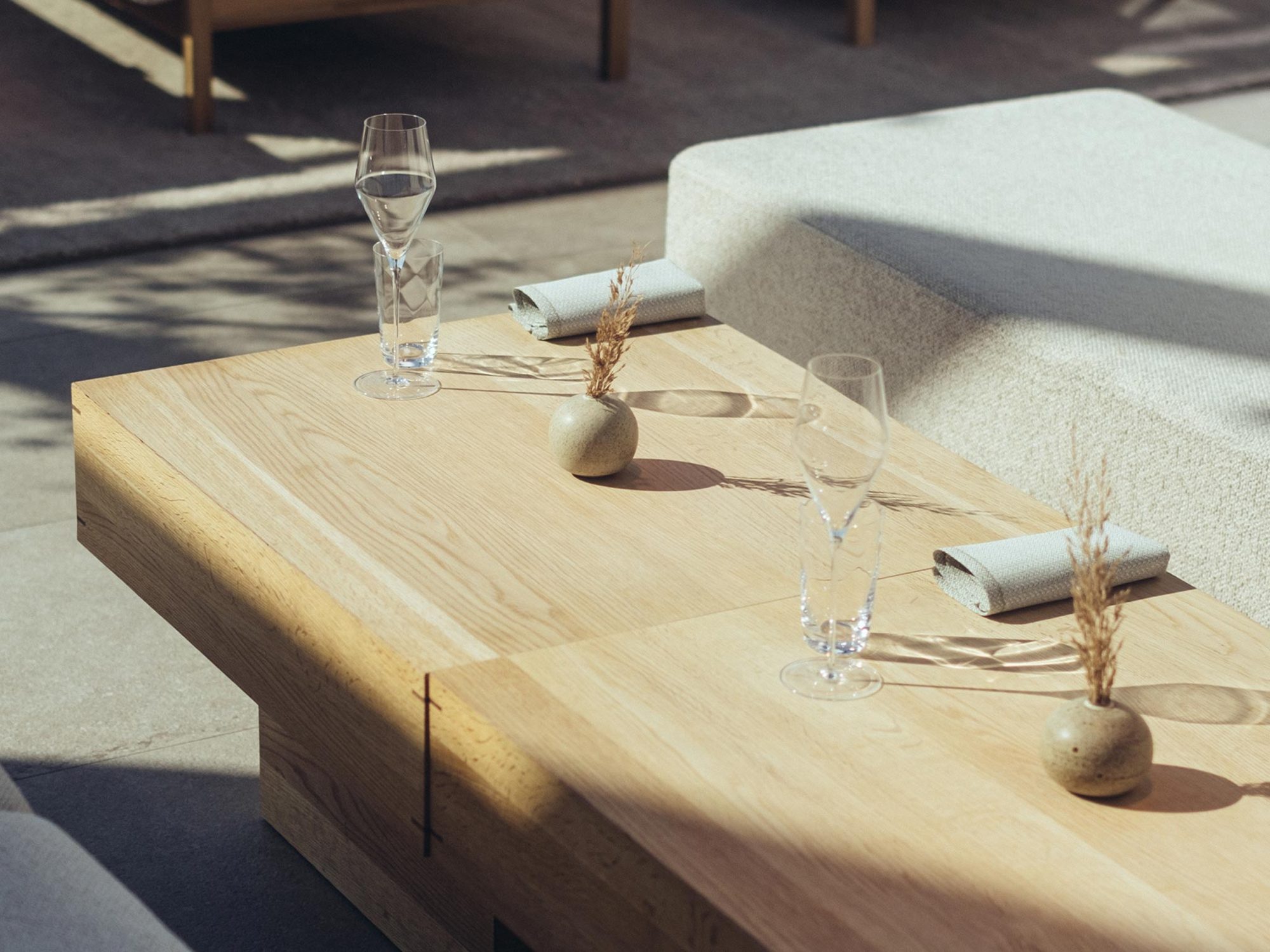 Restaurang ÄNG, Ästad Vingård — gedeckter Holztisch im gläsernen Pavillon