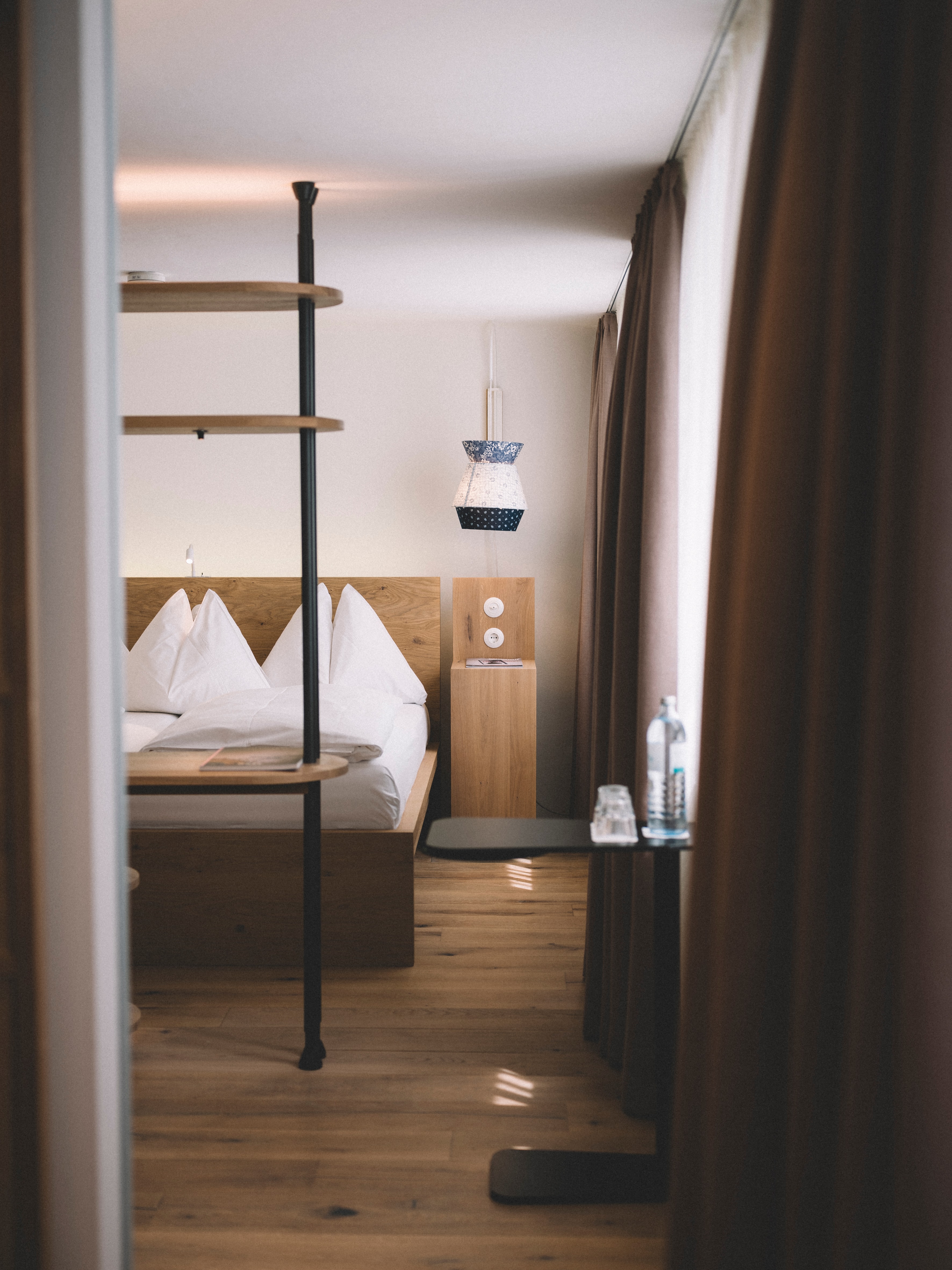 Arthotel Blaue Gans — Zimmer mit Bett vor verputzter Altstadtwand