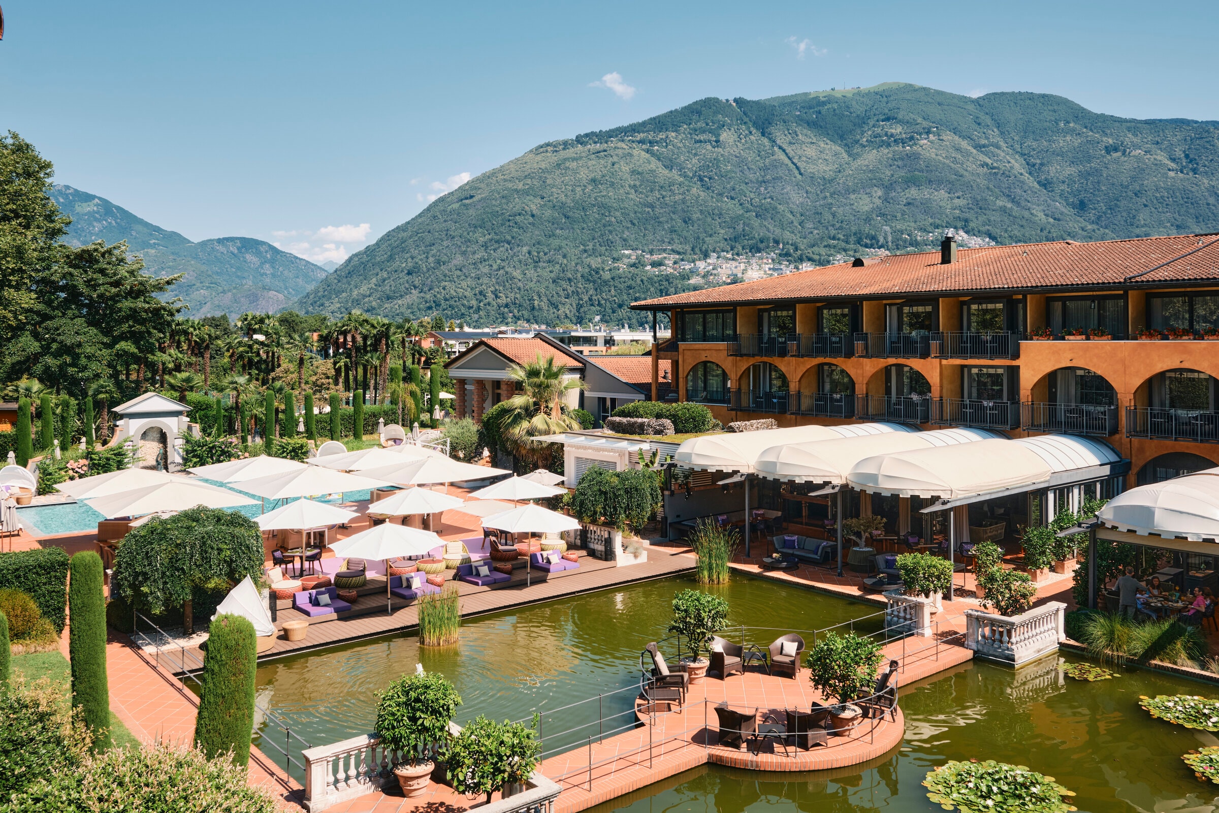 Giardino Ascona — Gebäude zwischen Palmen und Zypressen