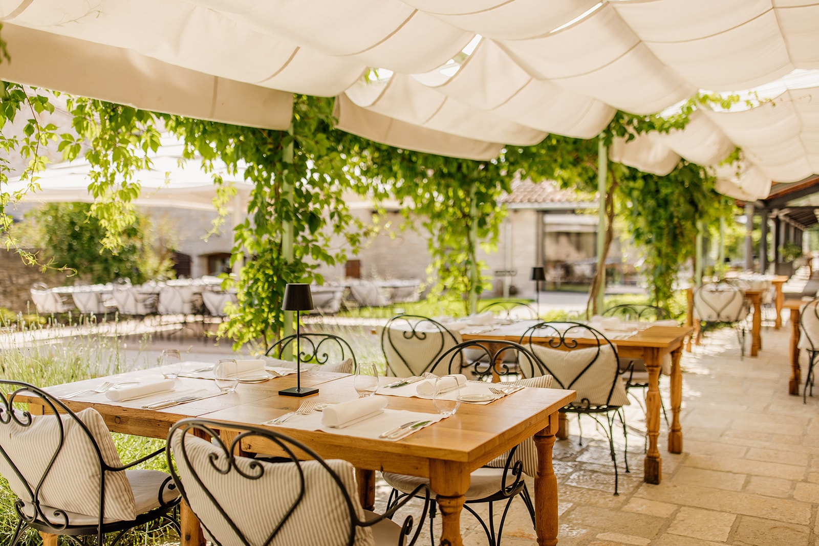 Meneghetti — gedeckte Tische zum Abendessen auf der überdachten Terrasse