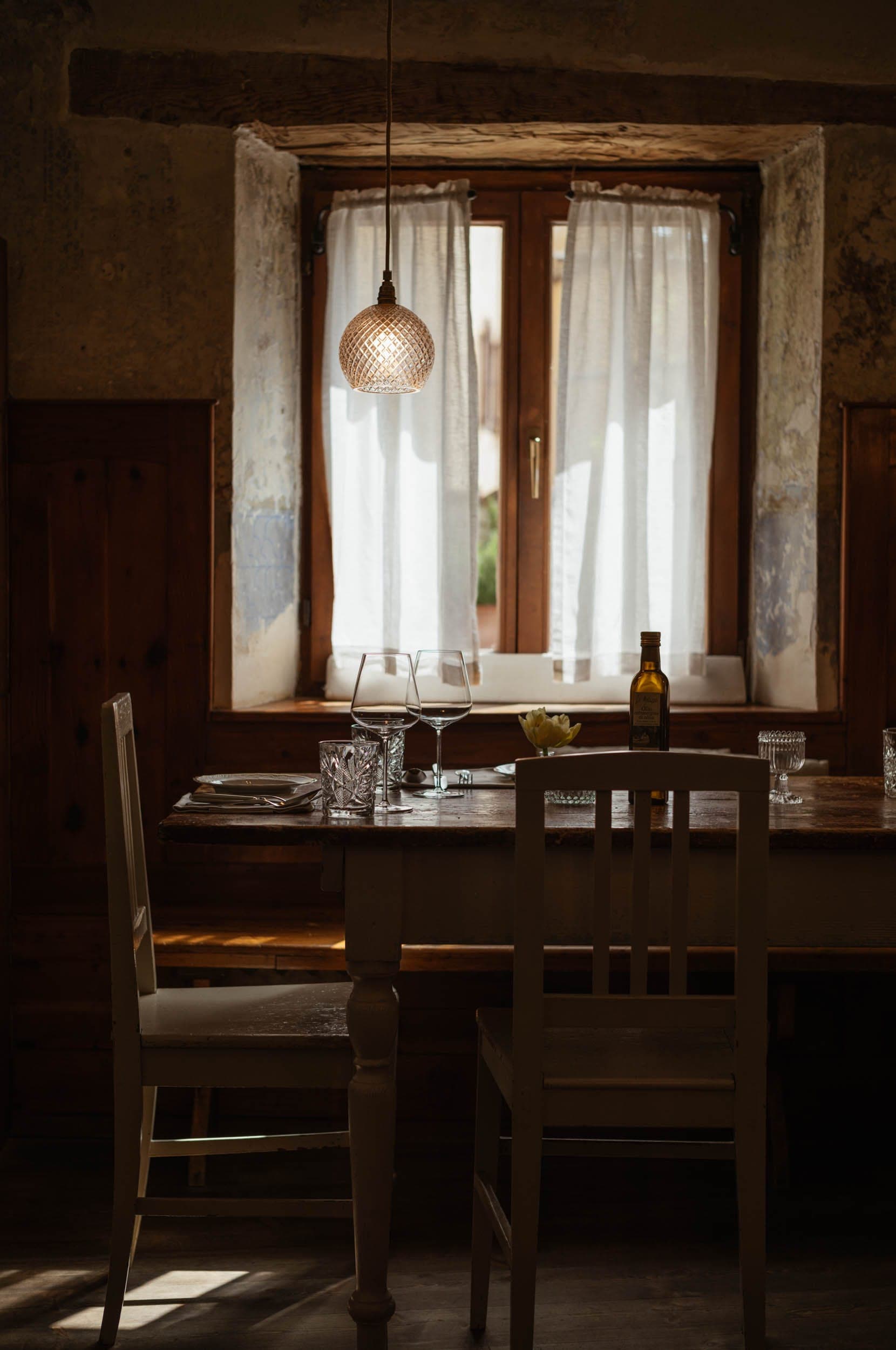 1477 Reichhalter — Restaurantraum mit gedeckten Tischen vor historischen Fenstern